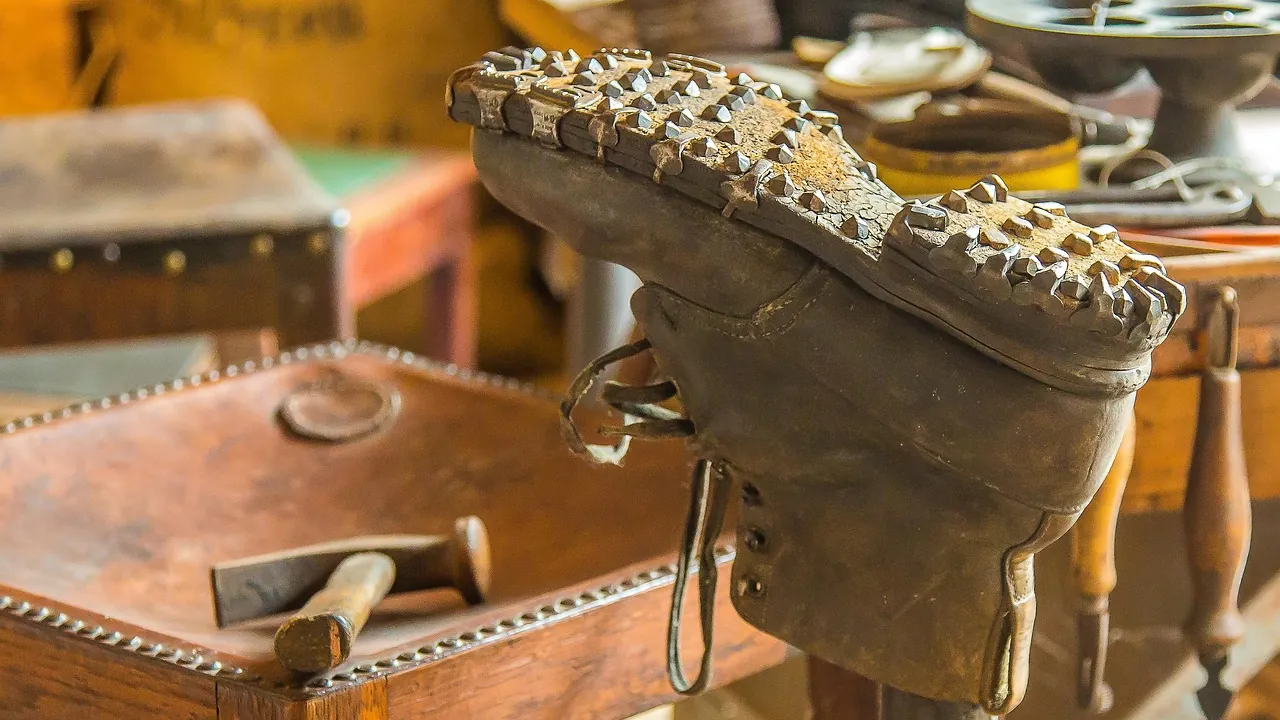 Une chaussure montée sur sa forme, outils de cordonnier posés sur l'établi